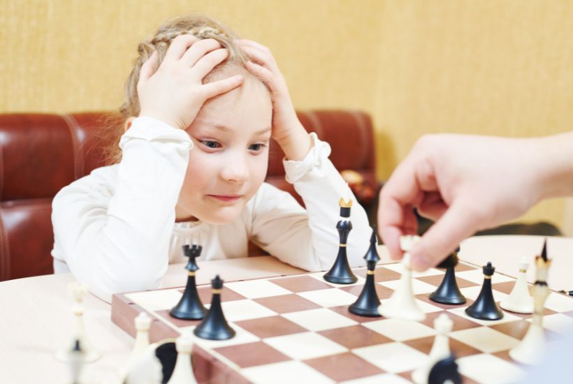 Child playing focuses on chess game