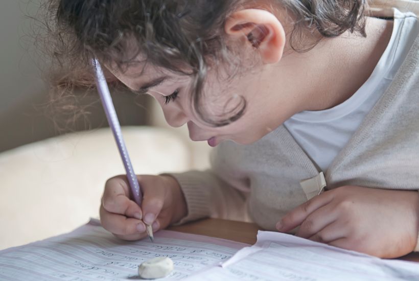 A child focusing on her writing homework