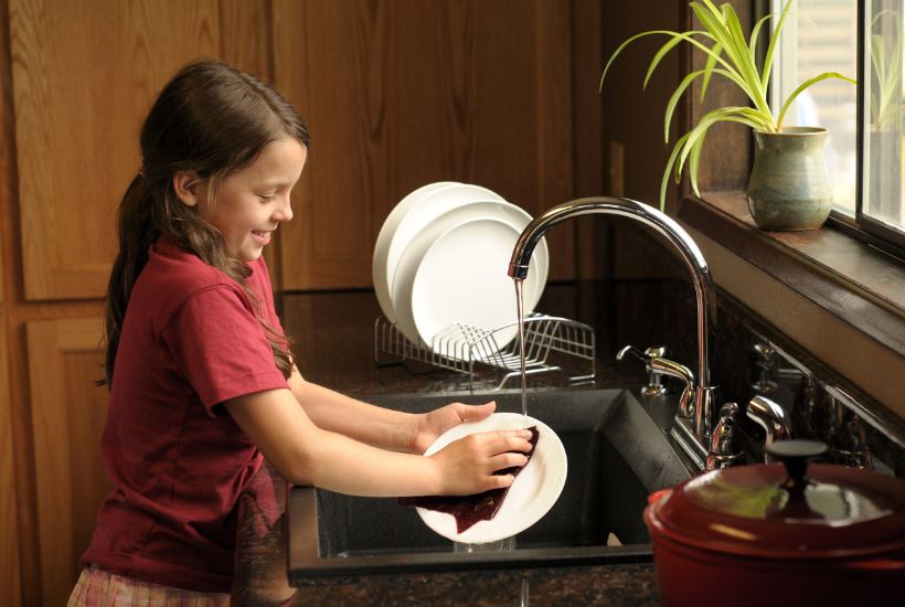 Girl proudly washing dishes
